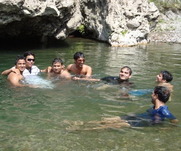 Six people group enjoying swimming in riverstream